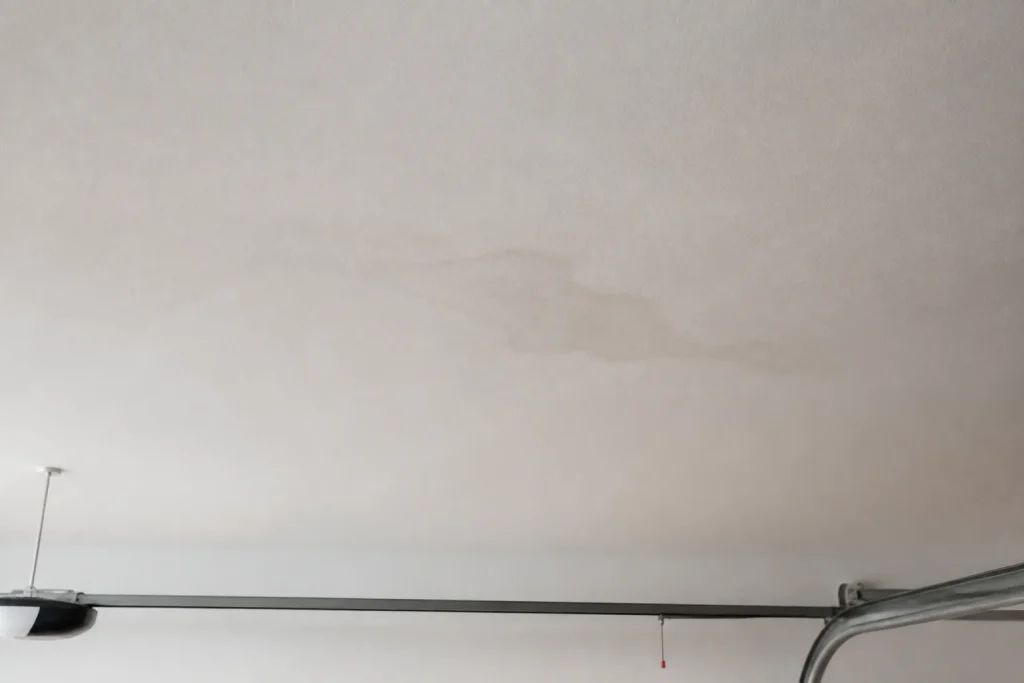 Teto de garagem residencial apresenta marca discreta de umidade.