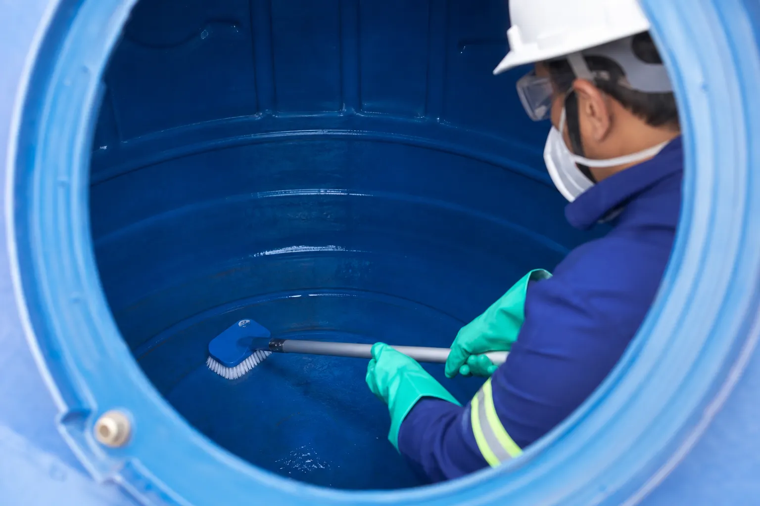Profissional higieniza caixa d’água vazia com equipamento adequado
