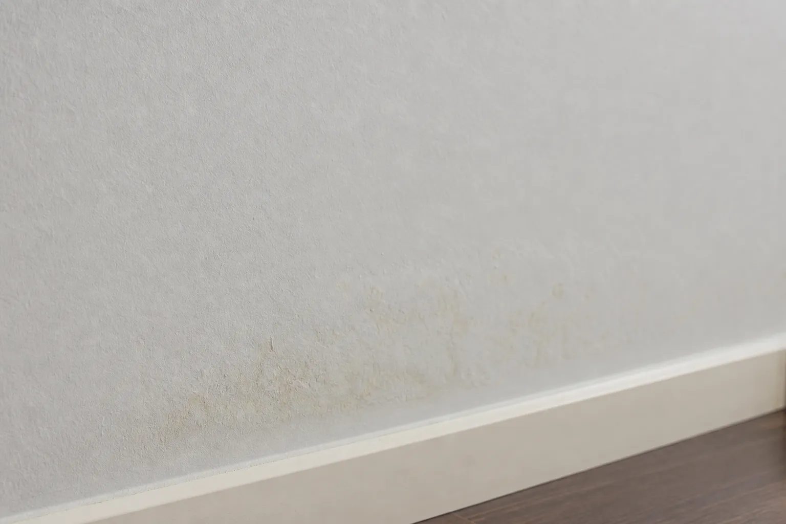 Parede com mancha discreta de umidade em apartamento, sinal de vazamento oculto em Pinheiros.