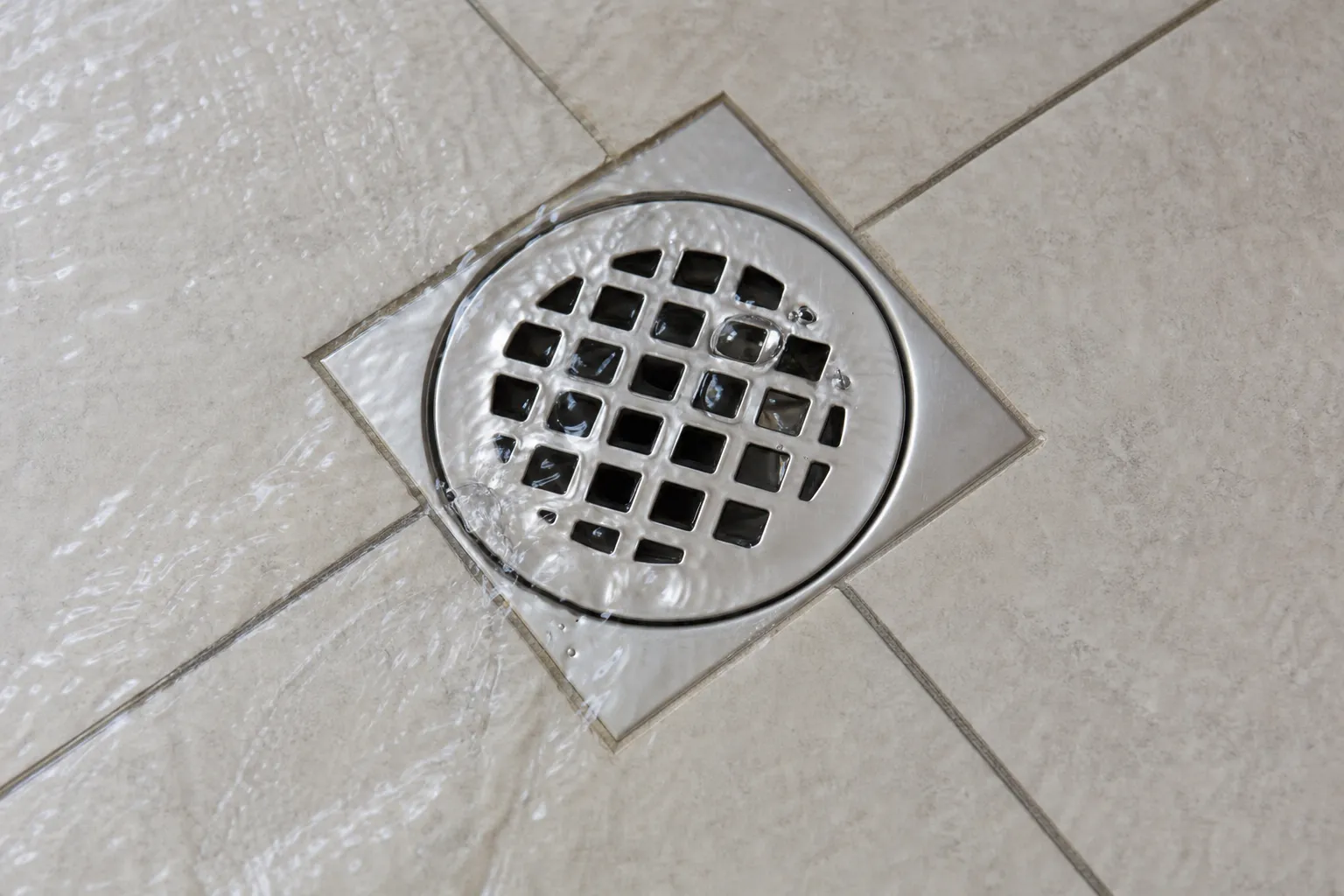 Ralo de banheiro é observado durante teste controlado de escoamento.