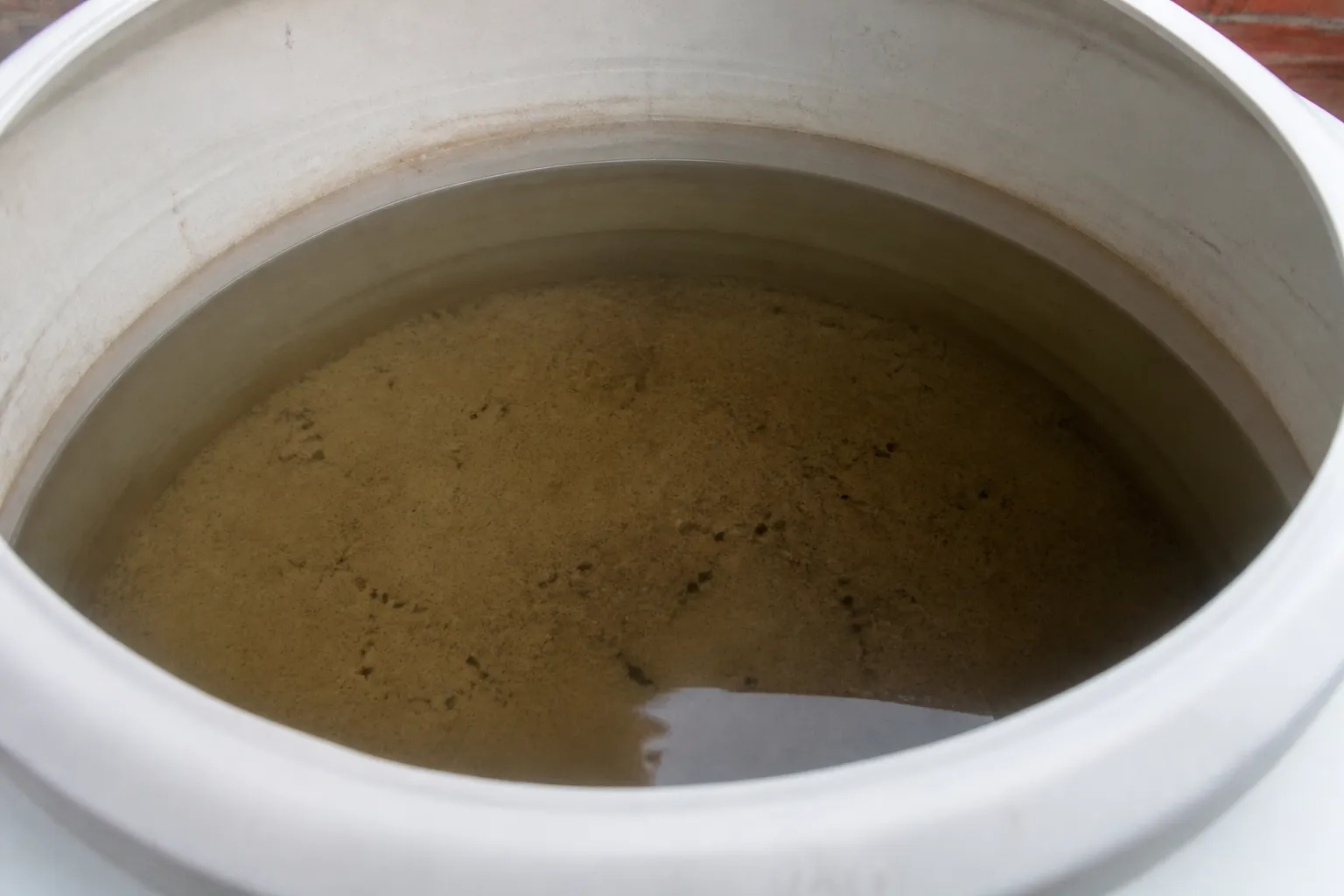 Profissional inspeciona caixa d’água aberta com proteção e acesso seguro.