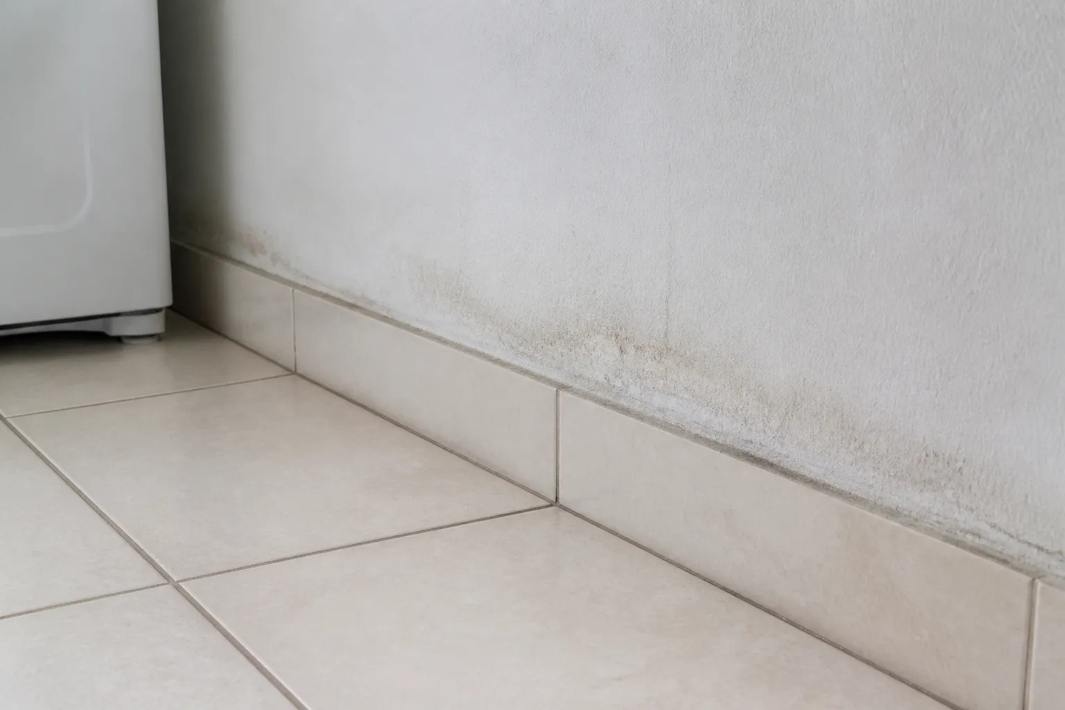 Piso de área de serviço mostra sinal discreto de umidade.