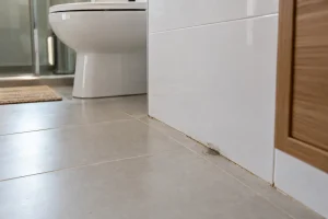 Pequena mancha de umidade em piso de banheiro após reforma.